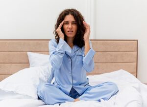 Mujer con dolor de cabeza e insomnio