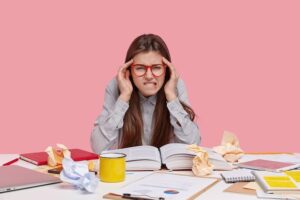 Estudiante con dolor de cabeza estudiando