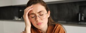 Mujer cansada con migraña en el trabajo
