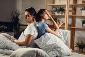 Pareja triste de espaldas en la cama